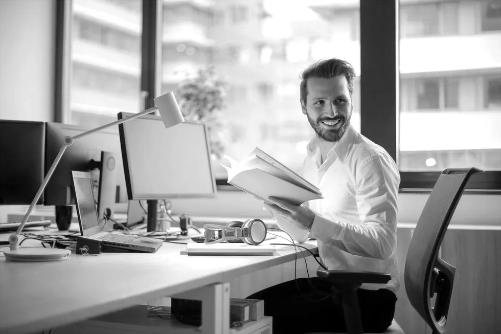 A bookkeeper reviewing financial records at a desk in an office