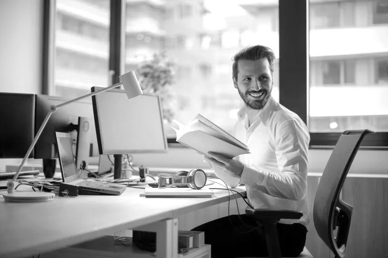 A bookkeeper reviewing financial records at a desk in an office